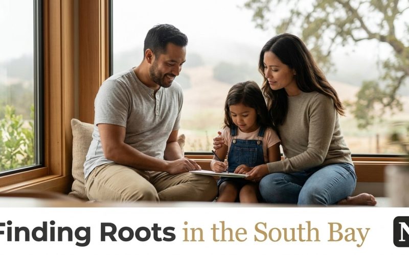 A family of three, parents and young daughter, drawing together by a large window with a view of hills.